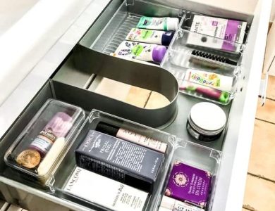 Offene Badezimmerschublade mit verschiedenen Hautpflege- und Hygieneprodukten in Fächern.
